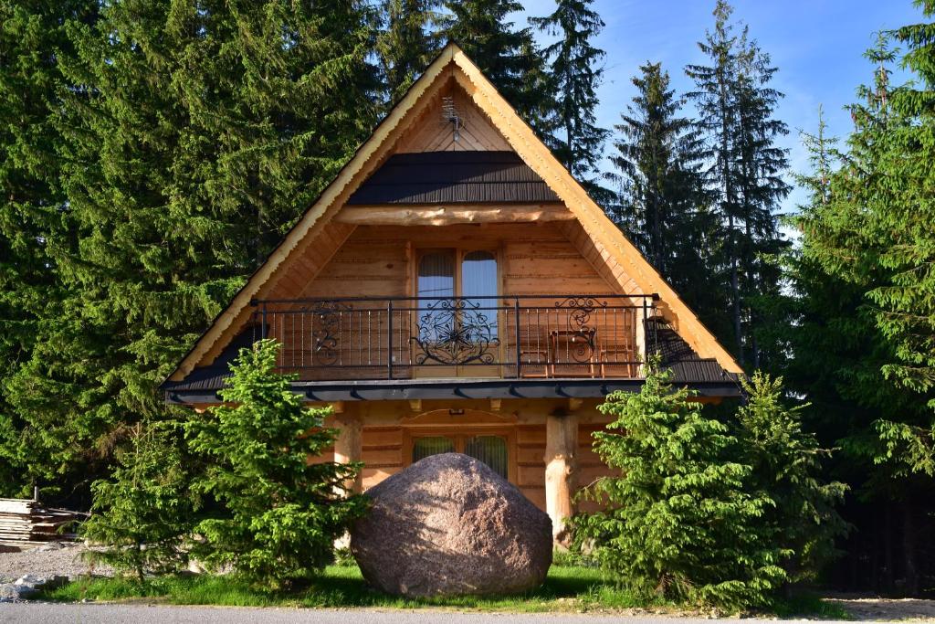 Cabaña de madera con balcón y roca en Domki u Bobaków, en Ząb