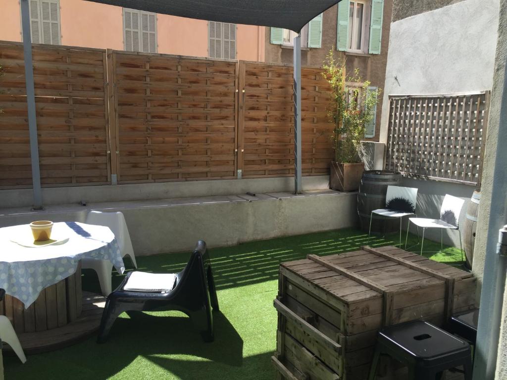 d'une terrasse avec une table, des chaises et une clôture. dans l'établissement Le Mourillon Appartement -Terrasse, à Toulon