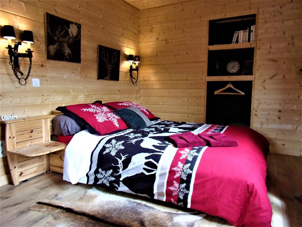 a bedroom with a bed in a wooden wall at Gîtes Le Cerf de Belledonne in Sainte-Agnès