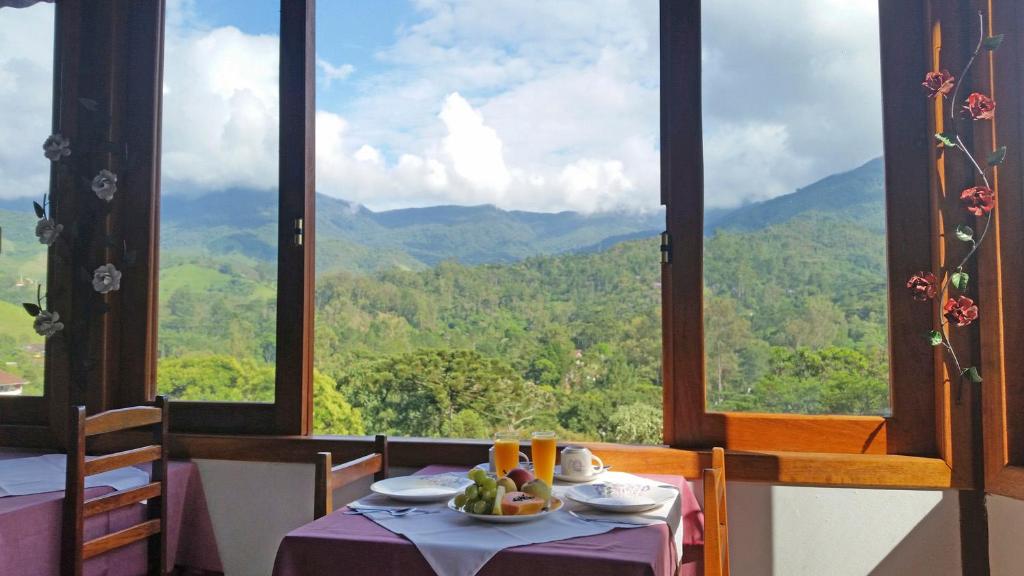 uma mesa num restaurante com vista para as montanhas em Pousada Sol Nascente em Visconde de Mauá