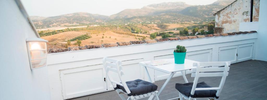 a table and chairs on a balcony with a view at Triplex Panoramic Ronda in Ronda