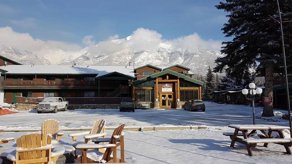 a lodge with snow covered mountains in the background at Rundle Mountain Lodge in Canmore