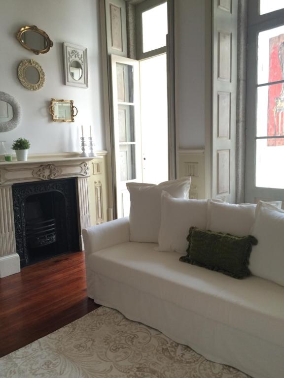 a white couch in a living room with a fireplace at GET a unique and luxury flat in Porto