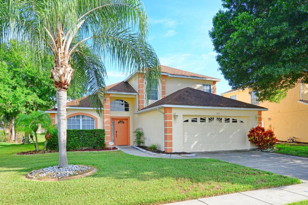 a palm tree in front of a house with a garage at Mickey's Lake Villa in Orlando