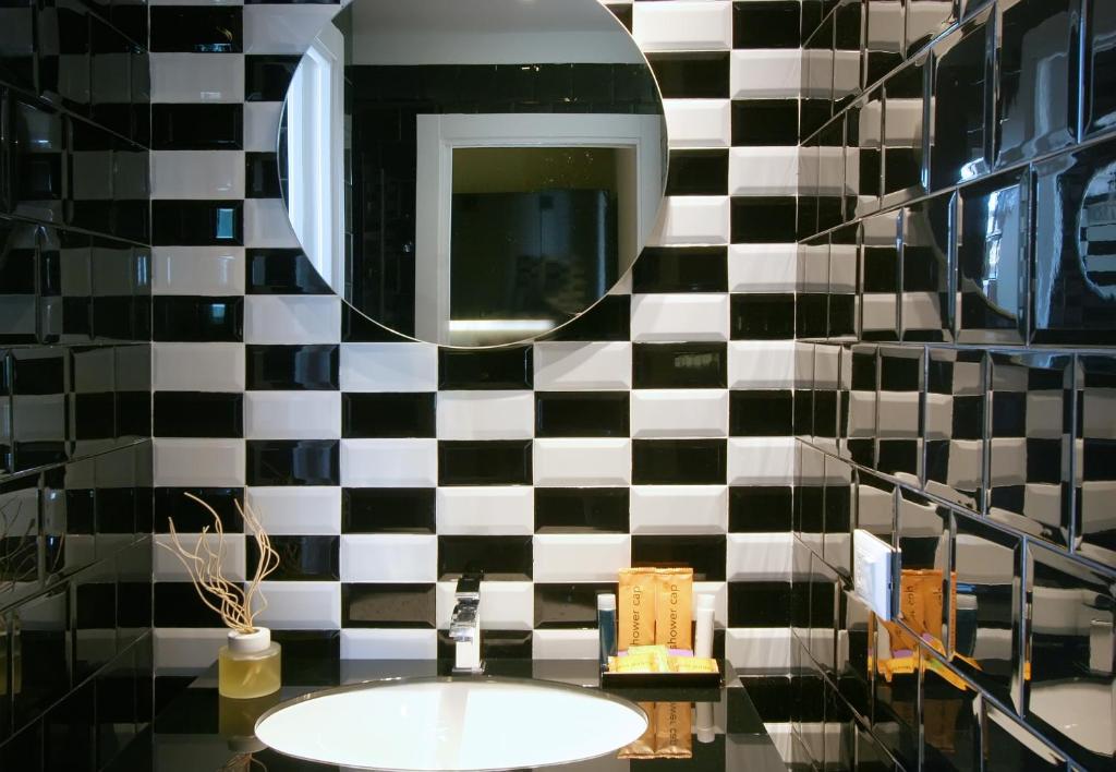 a bathroom with a black and white tiled wall at Residence Terminus in Rimini