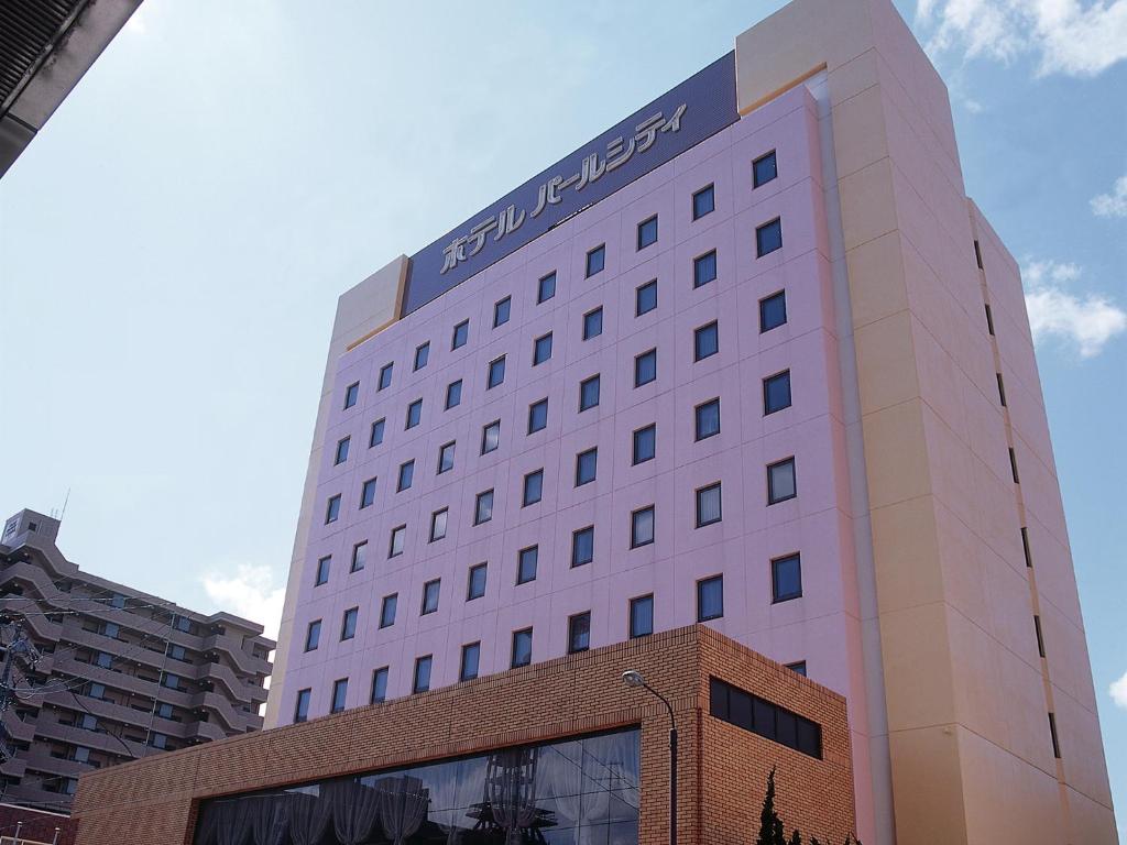 秋田的住宿－秋田川反珍珠城市飯店，一座高大的白色建筑,上面有标志