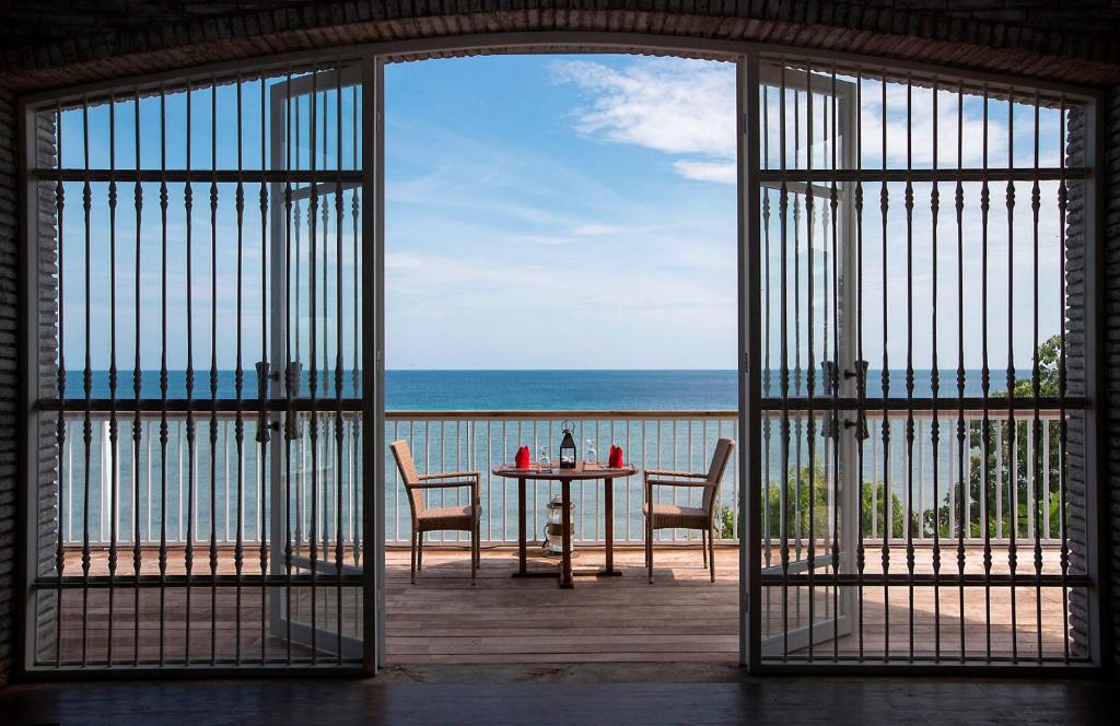 una puerta abierta a un patio con mesa y sillas en Plataran Menjangan Resort and Spa - CHSE Certified, en Banyuwedang