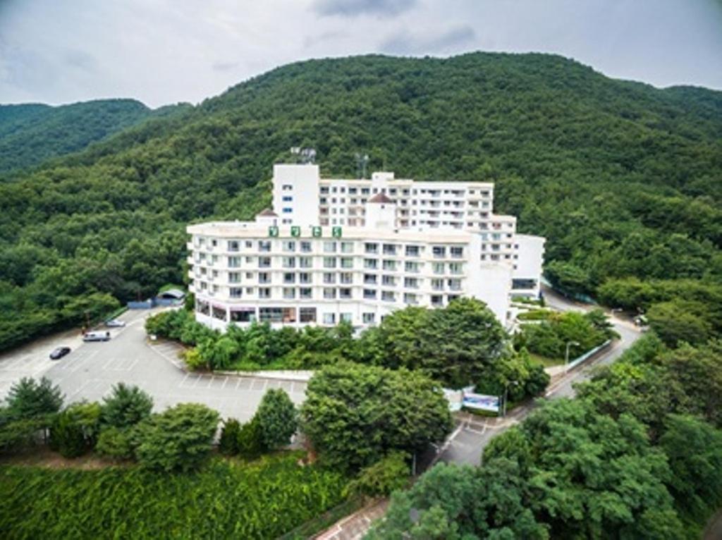 a large white building in the middle of a mountain at Bugok Ilsung Condo in Changnyeong