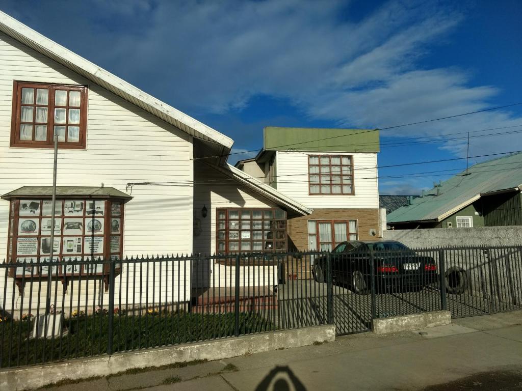 una casa blanca con un coche aparcado delante de ella en Hospedaje Familiar en Punta Arenas