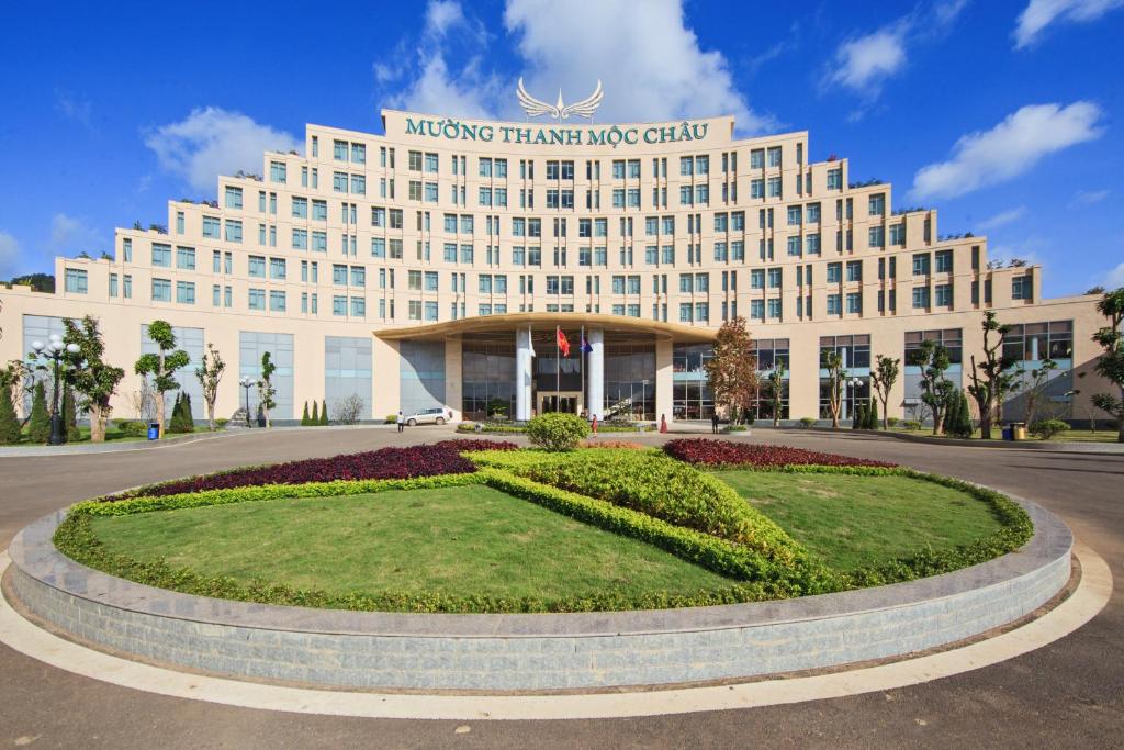 un grande edificio bianco con un cerchio davanti di Muong Thanh Holiday Moc Chau Hotel a Mộc Châu