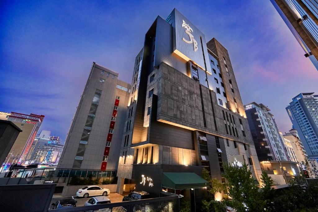 a tall building with a car parked in front of it at JB Design Hotel in Busan