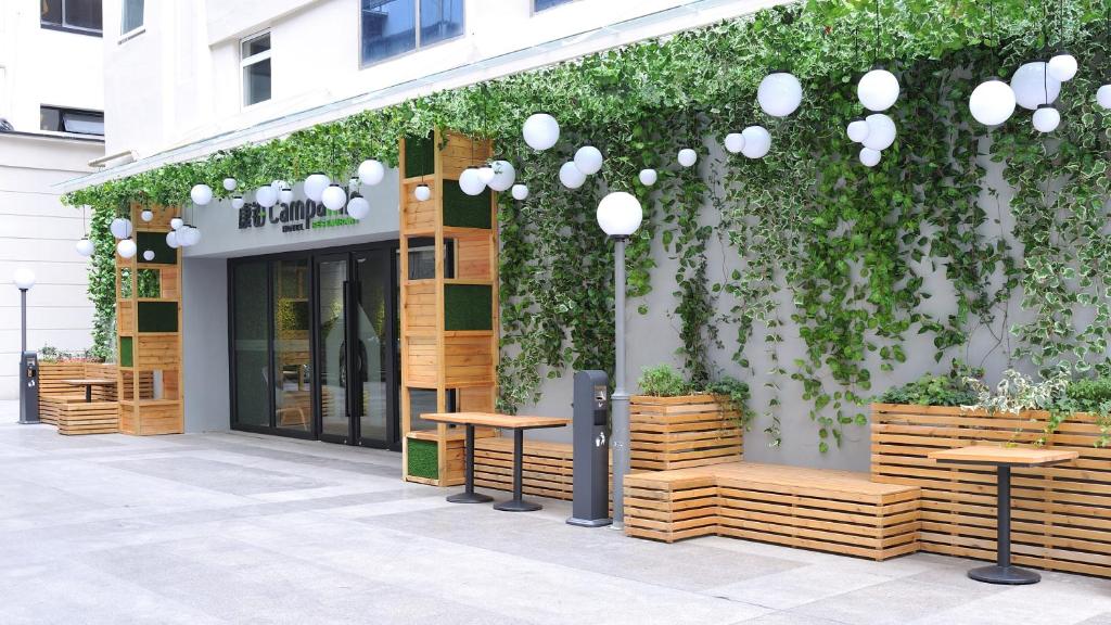 a store front with wooden benches and a green wall at Campanile Shanghai Natural History Museum Hotel in Shanghai