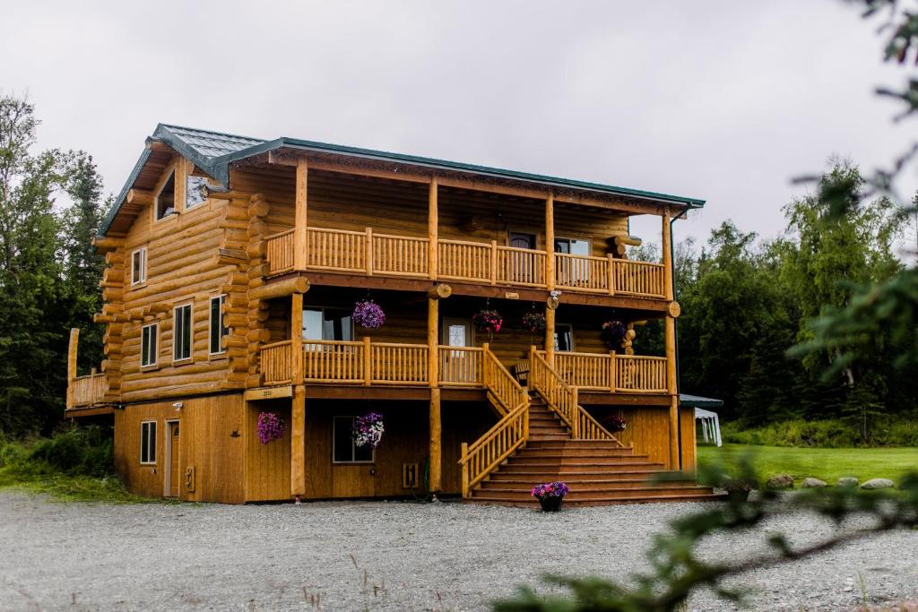 a log cabin with stairs and a balcony at Alaska Knotty Pine B&B in Palmer