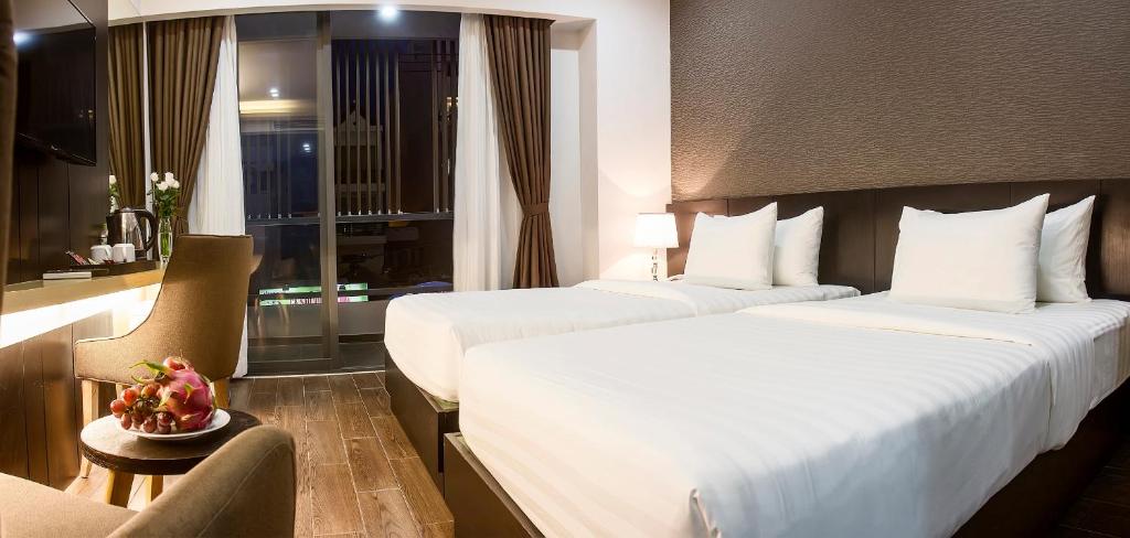 Giường trong phòng chung tại Golden Nha Trang Hotel