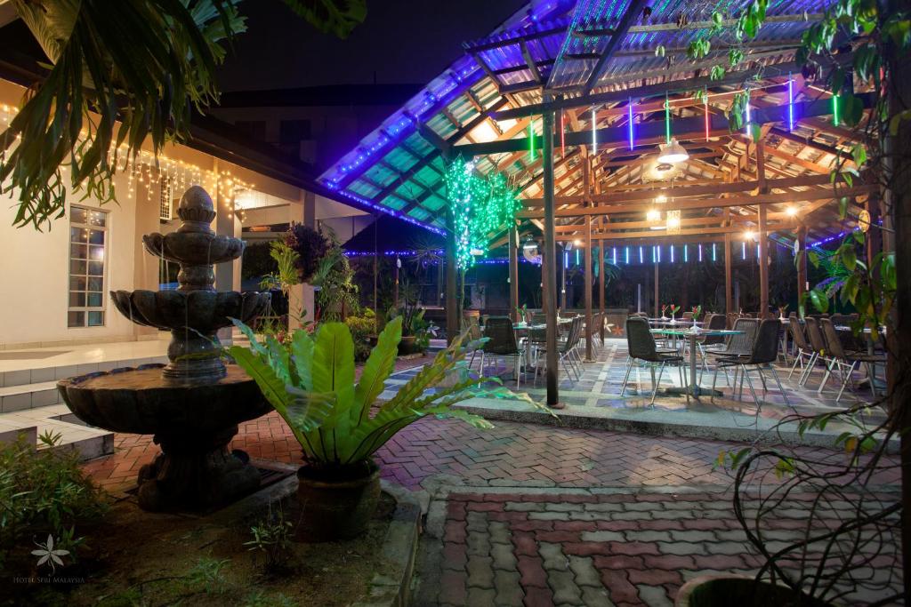 a courtyard with a fountain in a building at night at Hotel Seri Malaysia Johor Bahru in Johor Bahru