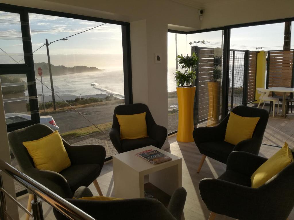 een wachtkamer met stoelen en uitzicht op de oceaan bij The Paralian Exclusive Guest House in East London