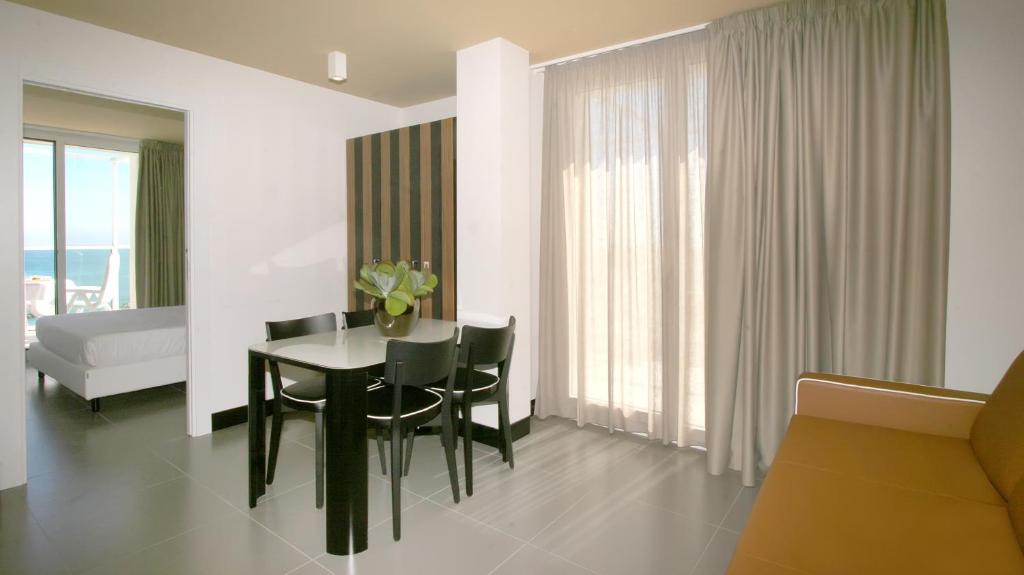 a dining room with a table and chairs and a bedroom at Residence Terminus in Rimini