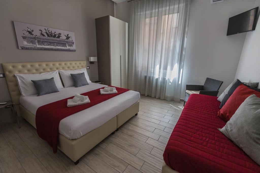 um quarto de hotel com uma cama grande e um sofá em Casantò guest home em Palermo