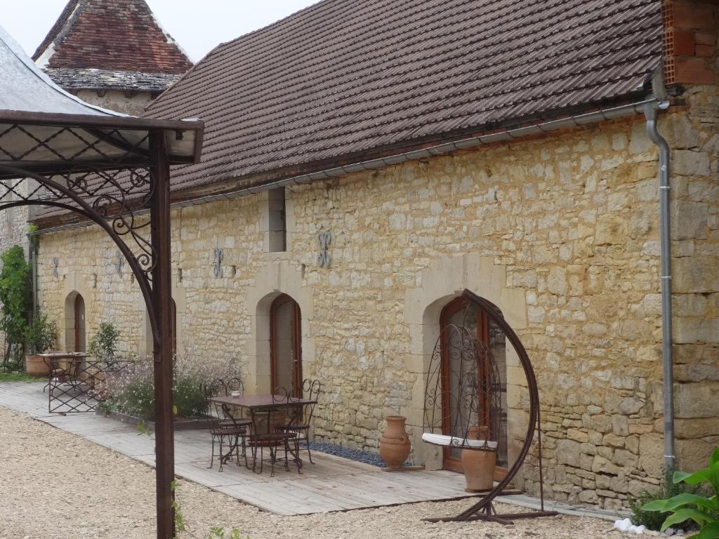 un antiguo edificio de piedra con mesa y sillas en Lacoste B&B en Saint-Clair