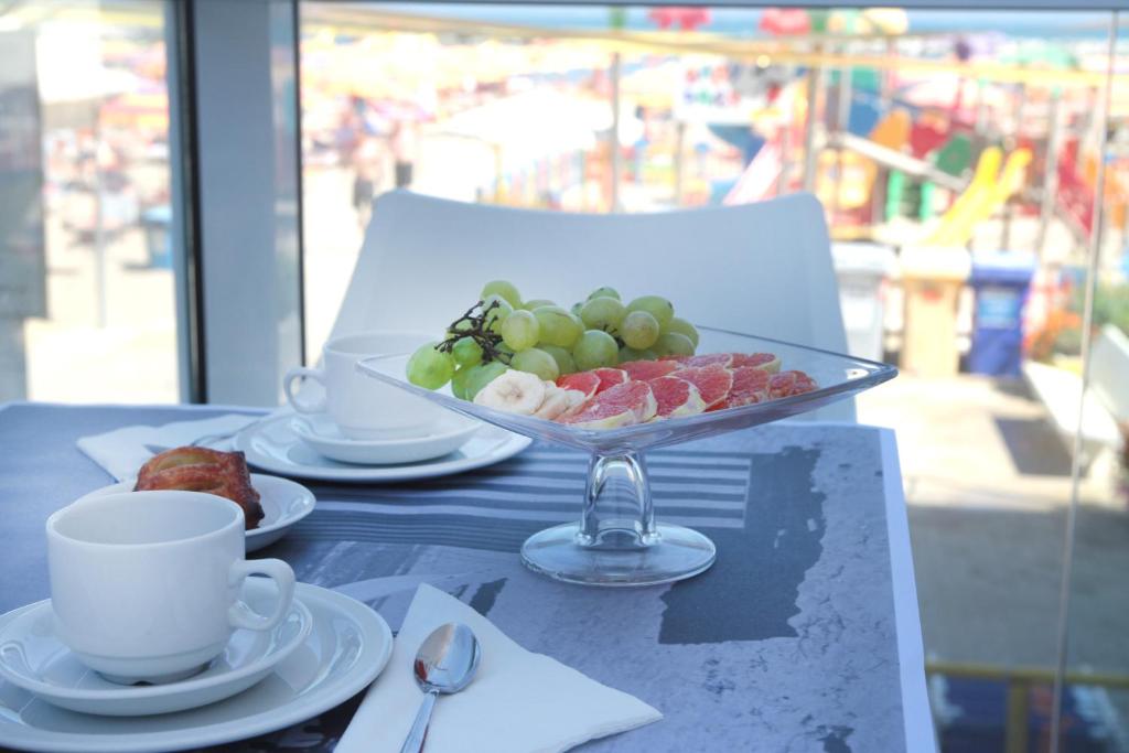 a table with a bowl of fruit and a cup of coffee at Residence Terminus in Rimini