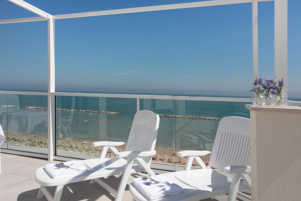 two white chairs sitting on top of a balcony at Residence Terminus in Rimini