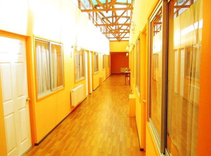 an empty hallway with yellow walls and wooden floors at Hostal Andalue Temuco in Temuco