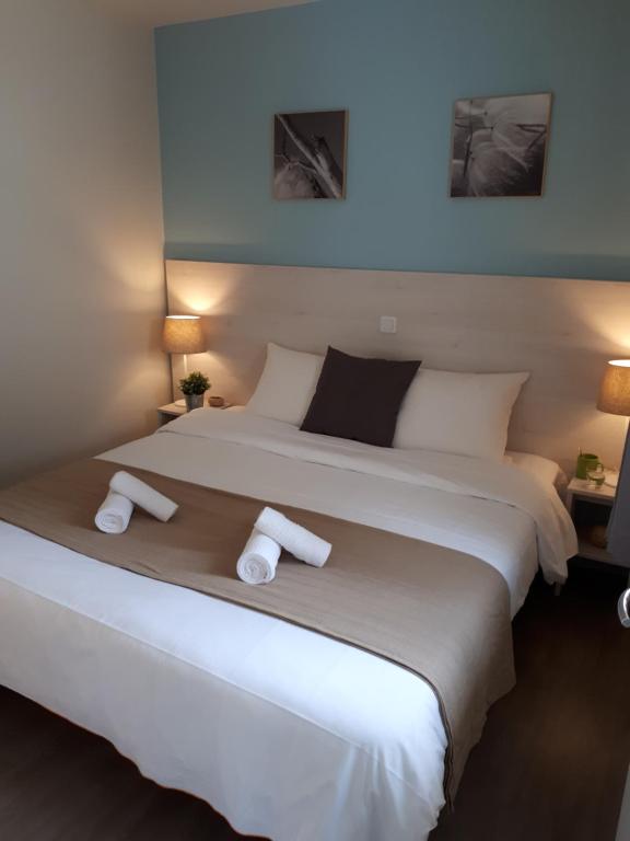 a bedroom with a large bed with two towels on it at VVF Normandie Forges-les-Eaux in Forges-les-Eaux