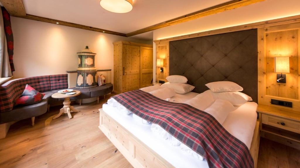 a bedroom with a large bed and a table and chairs at Verwöhnhotel Kristall in Pertisau
