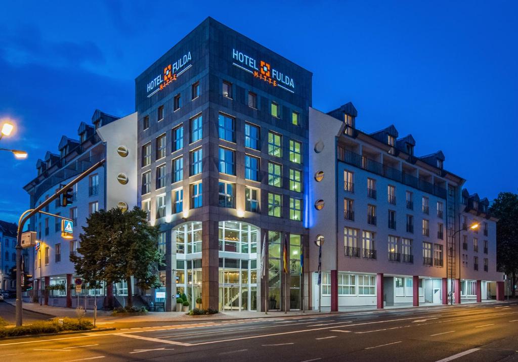 un bâtiment situé dans une rue de la ville la nuit dans l'établissement Hotel Fulda Mitte, à Fulde