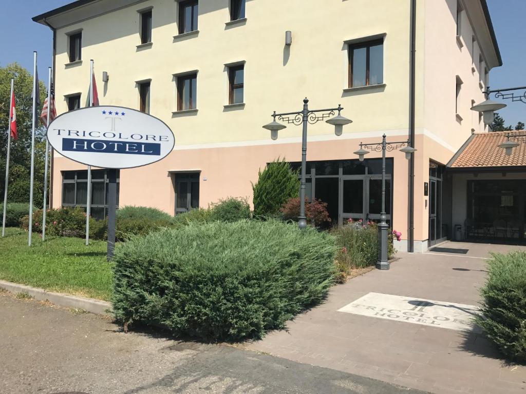 una señal de hotel frente a un edificio en Tricolore Hotel, en Gaida