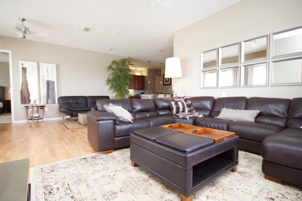 sala de estar con sofá de cuero y mesa en Cayview Condo #231543, en Orlando