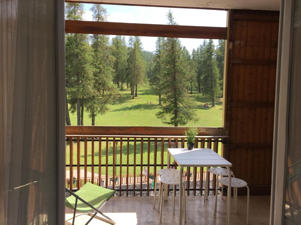 un balcone con tavolo, sedie e ampia finestra di Christiana studios en hyper centre de Valberg aux pieds des pistes a Valberg