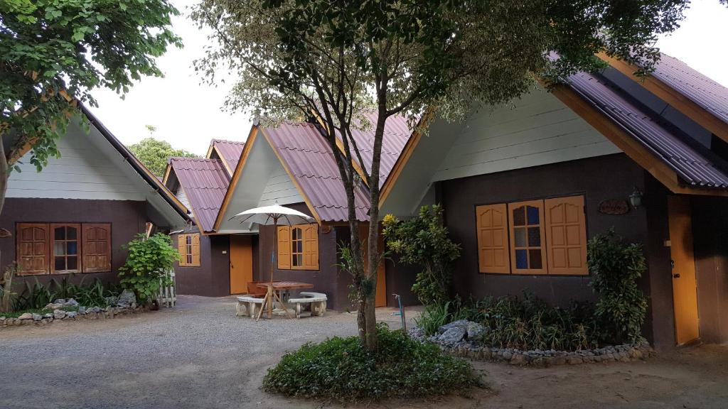 a group of houses with a table in front of them at Bansuan Inthanon resort -Classic House in Chom Thong