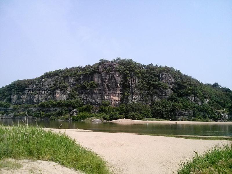 una montaña sentada sobre un cuerpo de agua en Okyeon Jeongsa, en Andong