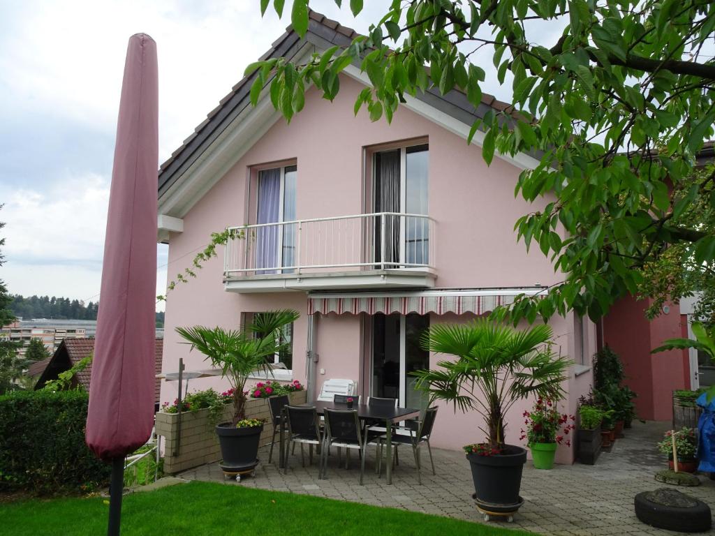 a house with a balcony and a table and chairs at B & B Hartenfels 73 in Lucerne