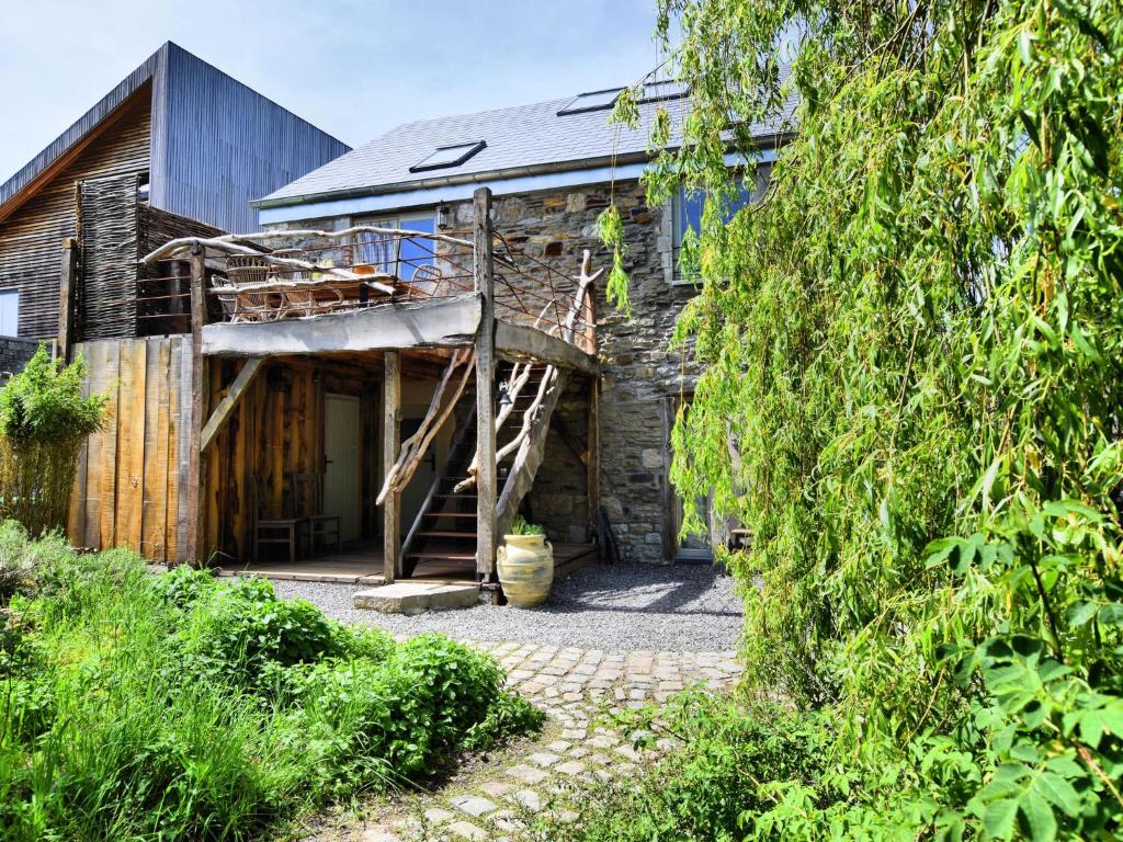 een stenen huis met een veranda en een trap bij Beautiful one of its kind home with a sauna in Oppagne