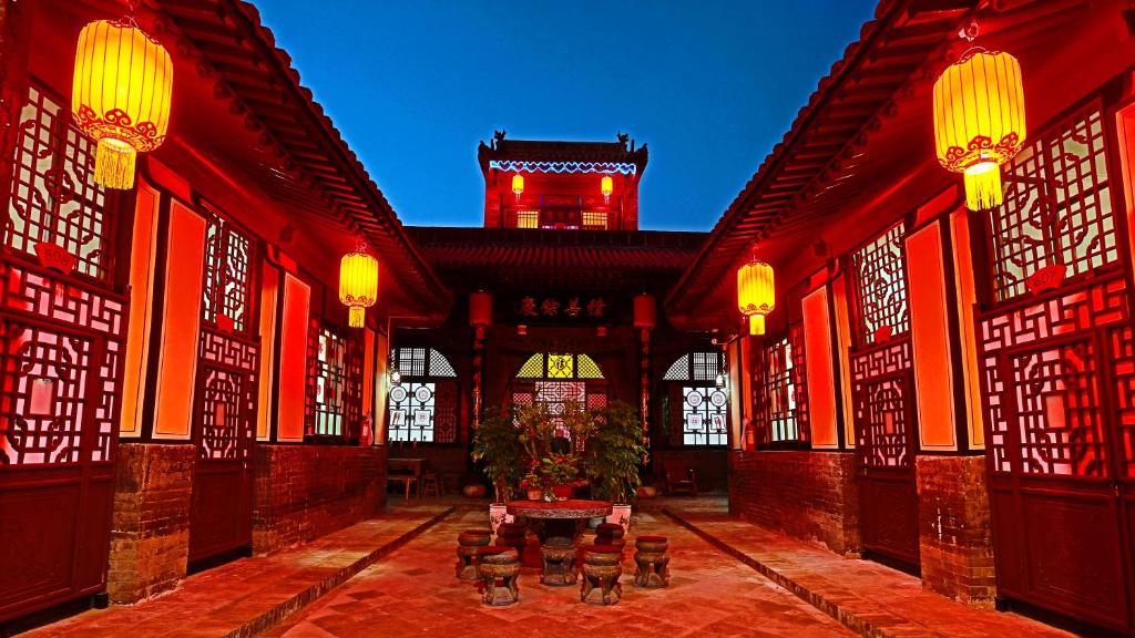 a courtyard with a building with a clock tower at Pingyao Xiangshengyuan Guest House in Pingyao
