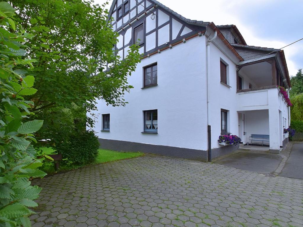 a white house with a cobblestone driveway at Spacious Holiday Home in Menkhausen near Ski Area in Schmallenberg