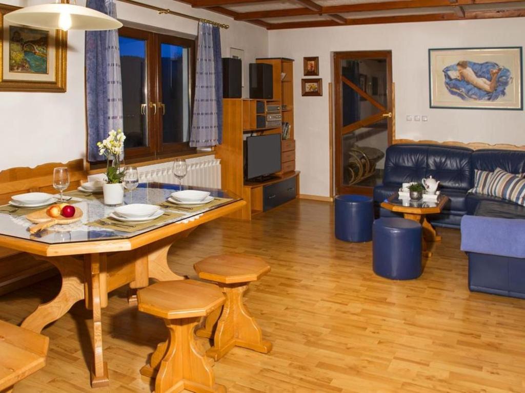 Kozji Vrh的住宿－Secluded Holiday Home with Jacuzzi in Kozji Vrh，客厅配有桌子和沙发