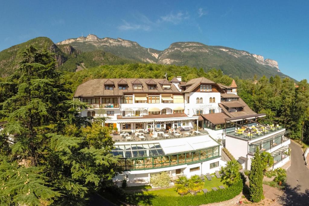 an aerial view of a building with mountains in the background at Hotel Lambrechtshof in Appiano sulla Strada del Vino