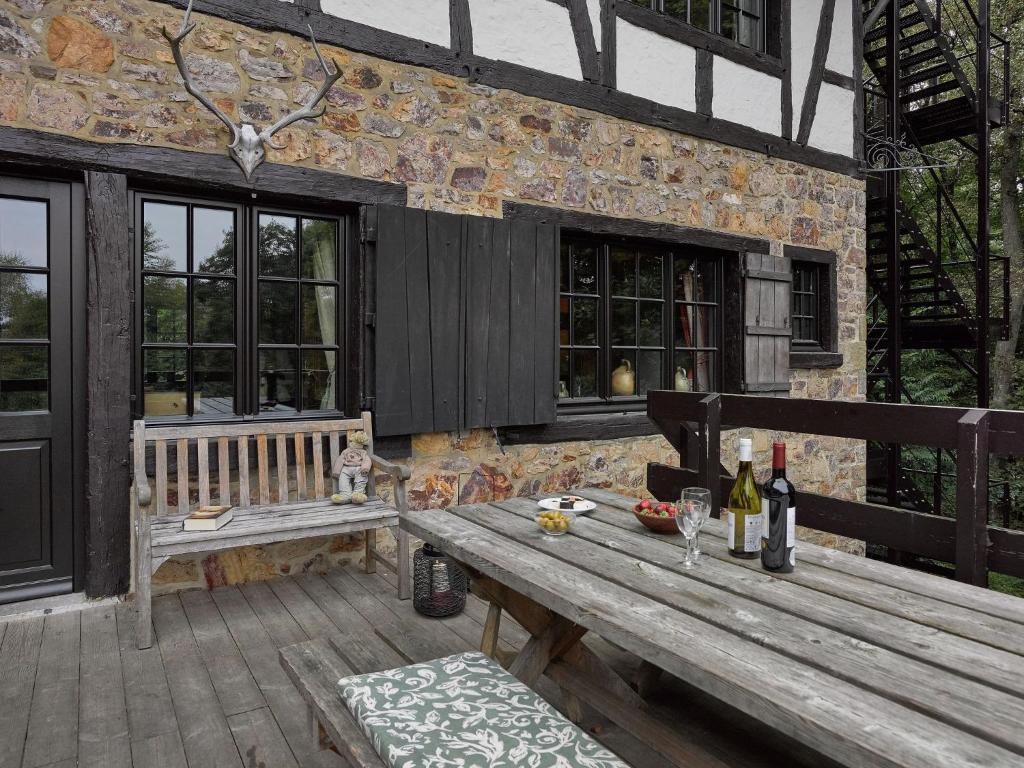 einen Holztisch und eine Bank auf einer Terrasse in der Unterkunft Stunning Villa in Spa with Terrace in Spa