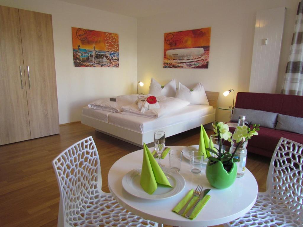 ein Wohnzimmer mit einem Tisch und einem Bett in der Unterkunft AMENITY-Garden-Apartments in München