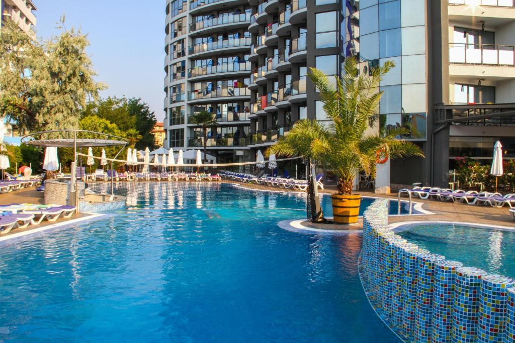 a swimming pool in front of a tall building at Smartline Meridian Hotel in Sunny Beach