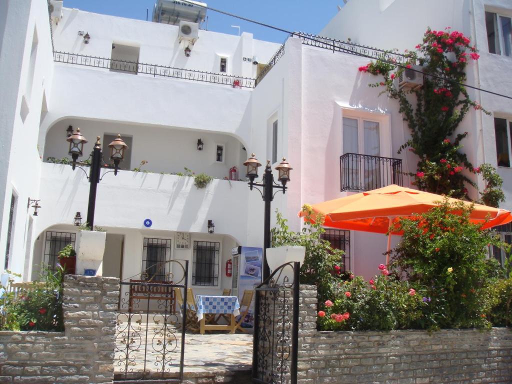 an orange umbrella in front of a white building at Istankoy Butik Pansiyon in Bodrum City