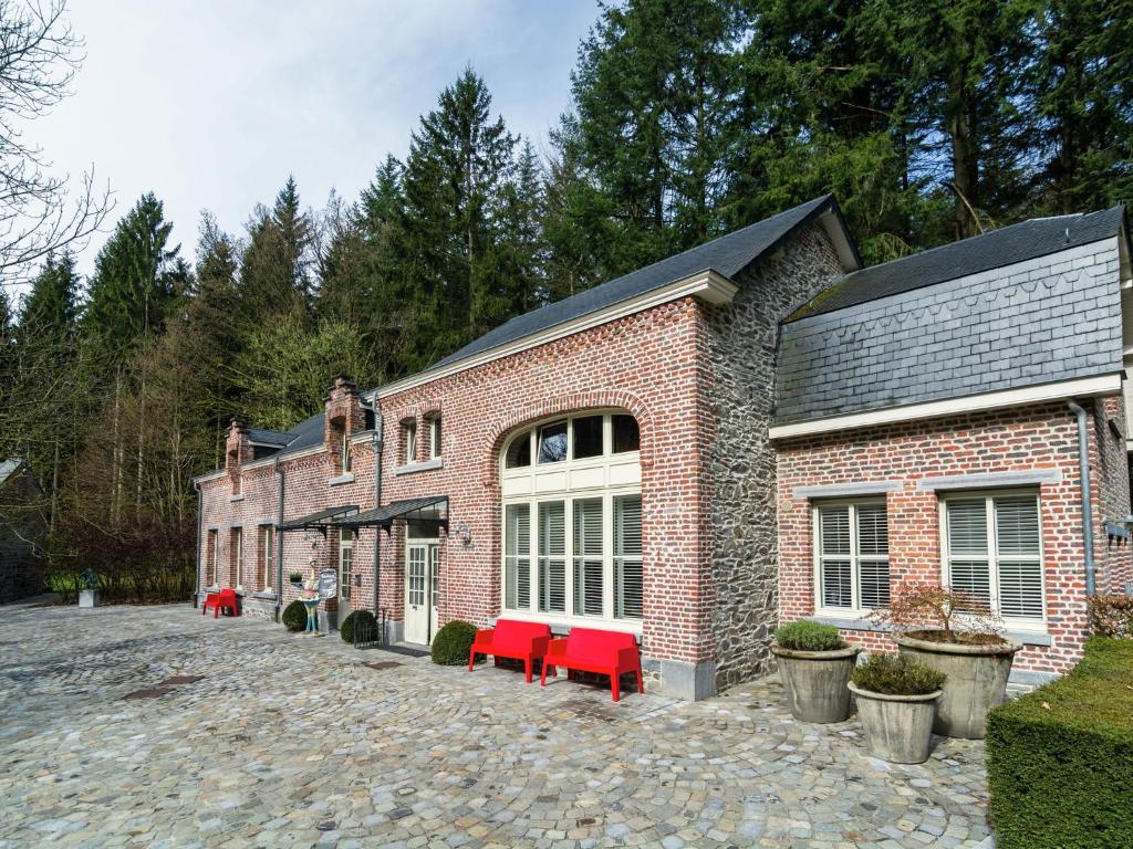 a brick building with red chairs in front of it at Luxury home in Gedinne with bubble bath and sauna in Gedinne
