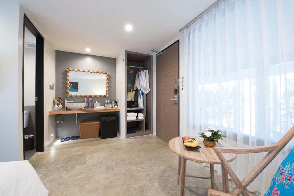 a bedroom with a table and a mirror in a room at Deevana Krabi Resort in Ao Nang Beach