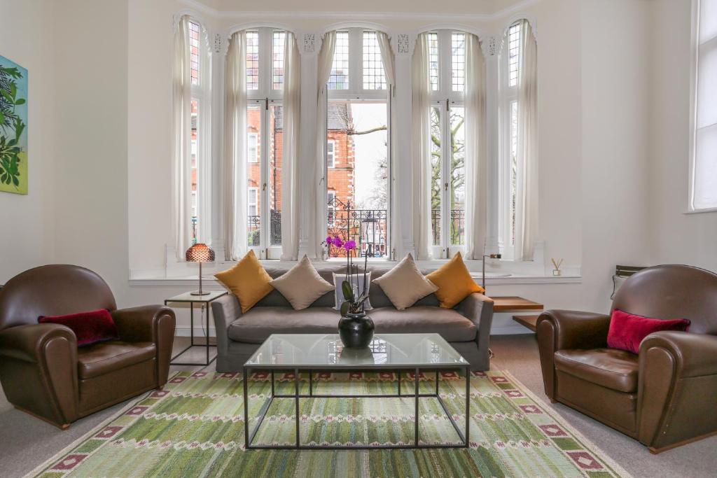 ロンドンにあるAhometorent - Charming Apartmentのリビングルーム(ソファ、椅子2脚、テーブル付)