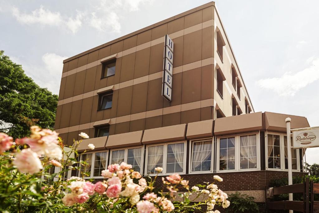 Um edifício com flores cor-de-rosa à frente. em Hotel Hannover Airport by Premiere Classe em Hanôver