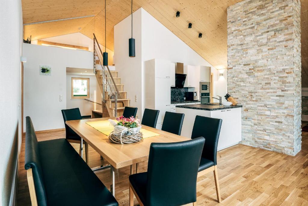 een eetkamer en een keuken met een houten tafel en stoelen bij Nowders Apartments und Zimmer in Nauders