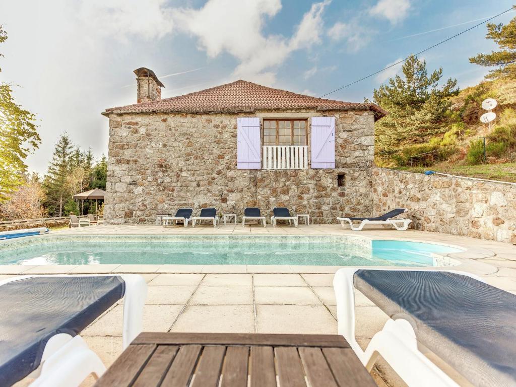 a villa with a swimming pool in front of a house at Charming Farmhouse in Cros de G orand with Swimming Pool in Cros-de-Géorand